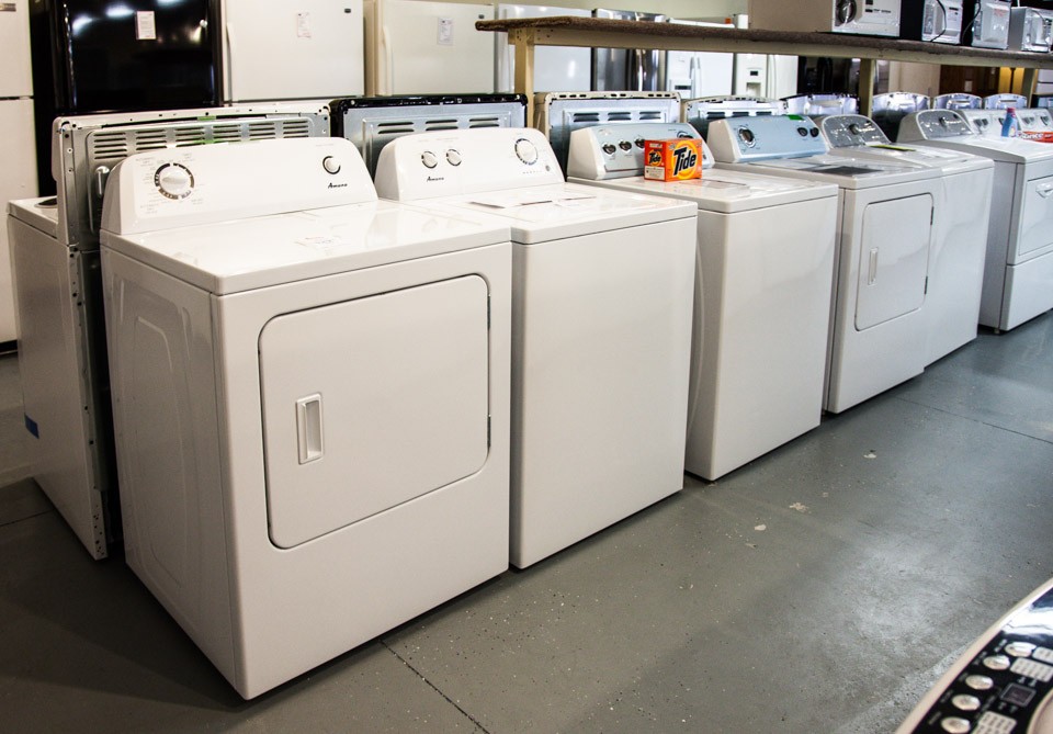 Row of white washers and driers in the showroom