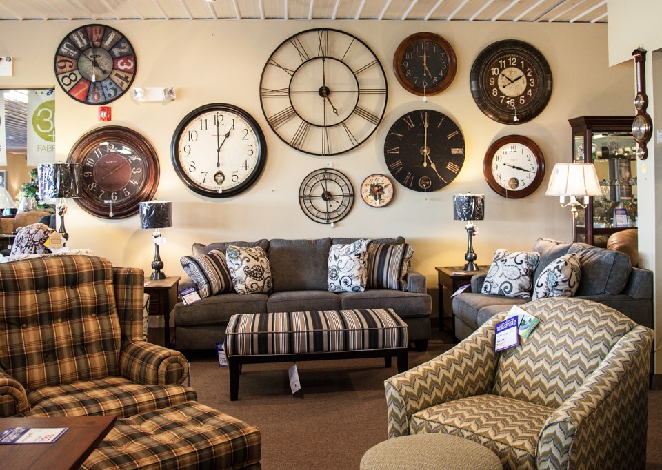 Assortment of sofas, chairs and wall clocks on display
